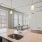 Spacious and well lit kitchen with wood floors and black appliances 