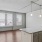 Spacious and well lit kitchen with wood floors and black appliances 