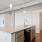 Spacious and well lit kitchen with wood floors and black appliances 