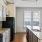Spacious and well lit kitchen with wood floors and black appliances 
